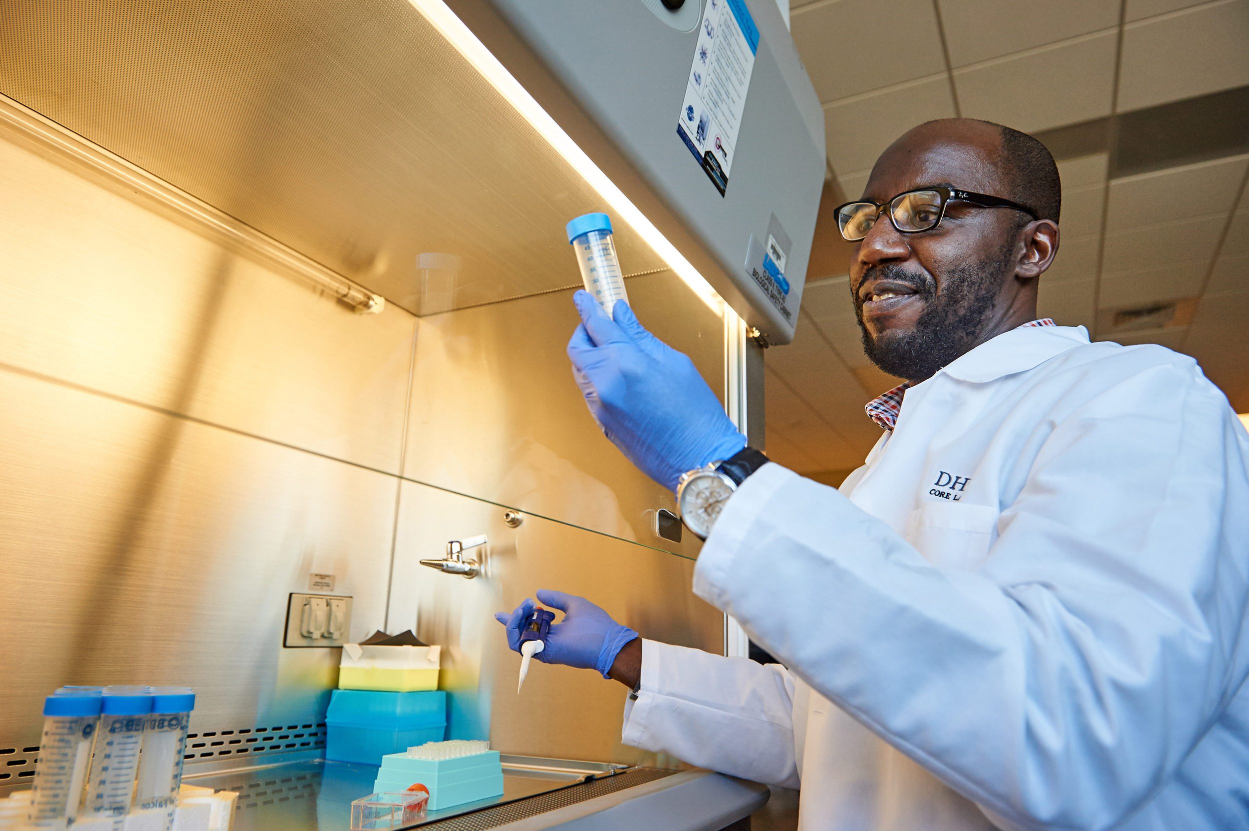 Man in lab setting holding up test tube