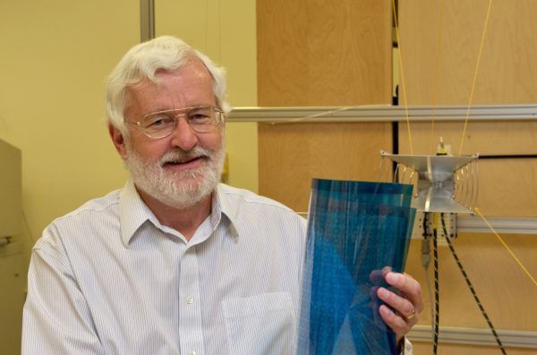 Michael Fiddy in his lab with metamaterials, a think blue sheet.