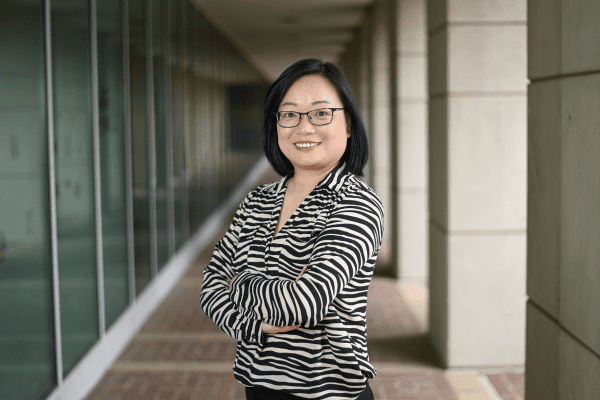 Shaoyu Li smiles with her arms crossed.